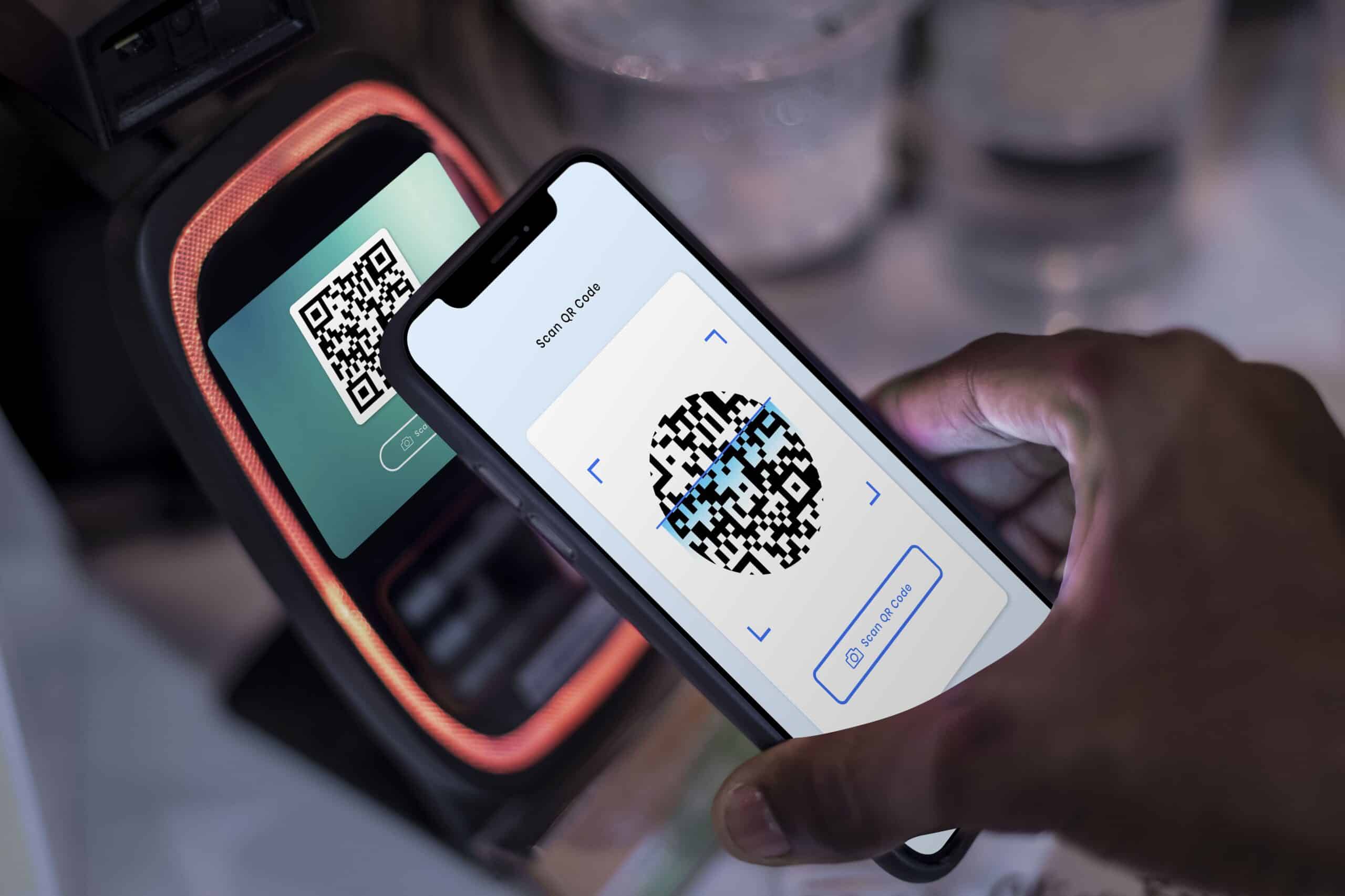 Persona escaneando un código QR en un punto de control de accesos con su móvil