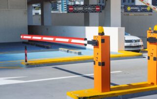 Vehículo detenido frente a una barrera automática durante el control de acceso vehicular en una empresa.